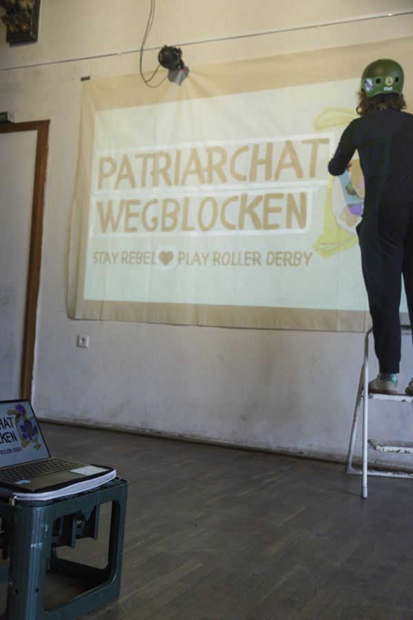 Person arbeitet an einem Banner im Peter-Weiss-Haus