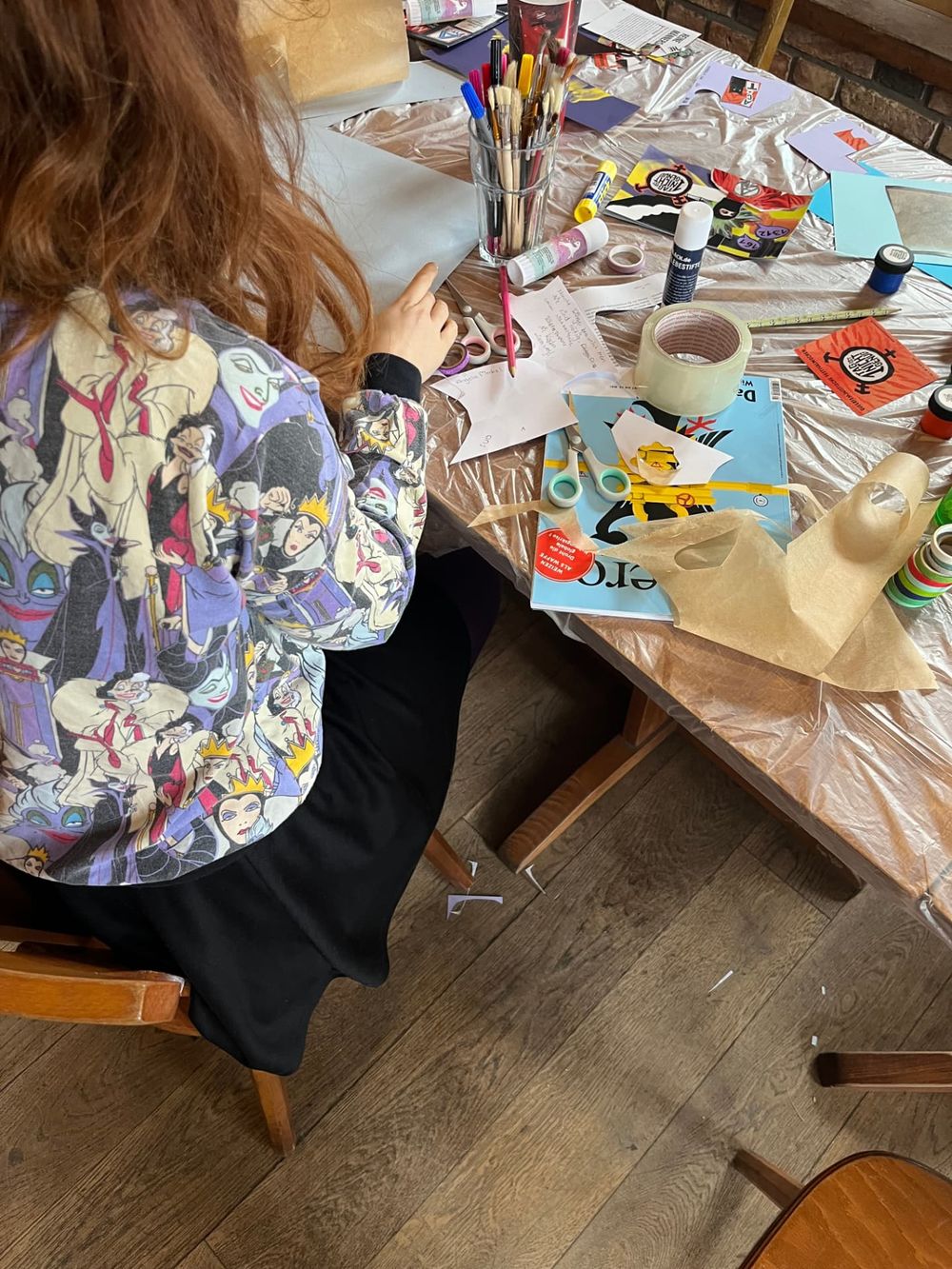 Person gestaltet Plakate bei einem Workshop im Peter-Weiss-Haus