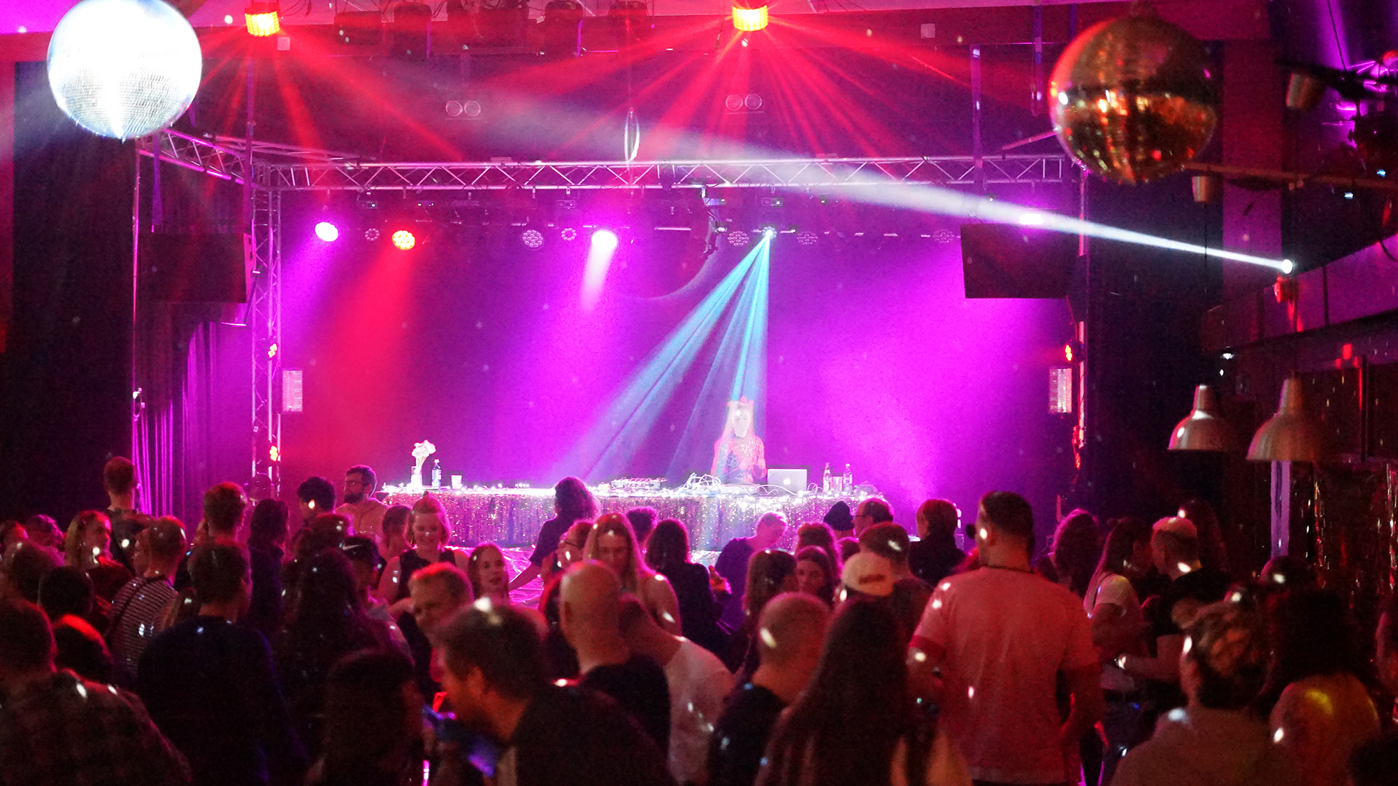 Tanzveranstaltung mit Discokugel und pinkem Licht